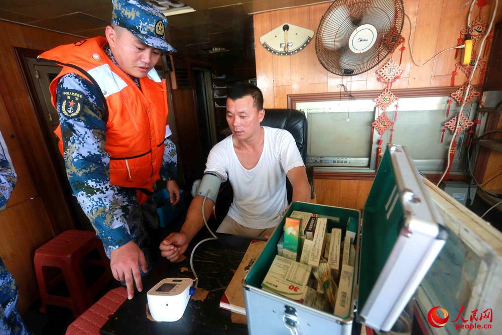 徐州艦軍醫為中國籍漁船8666船員量血壓。 張千 攝