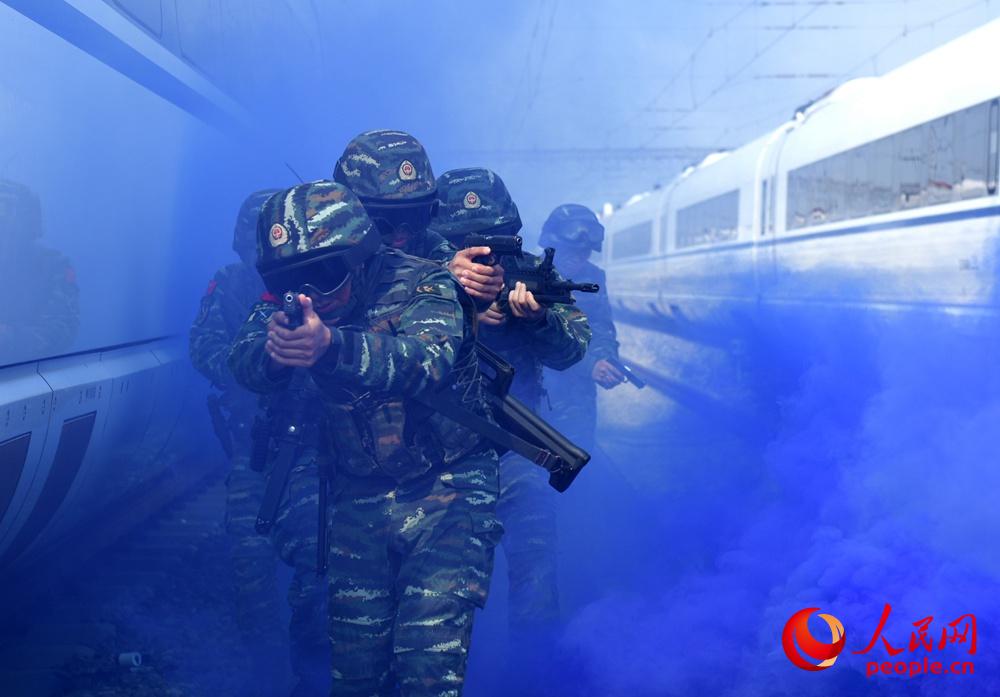 2018年7月30日，安徽合肥，武警特战队员在烟雾的掩护下抵近“目标”。