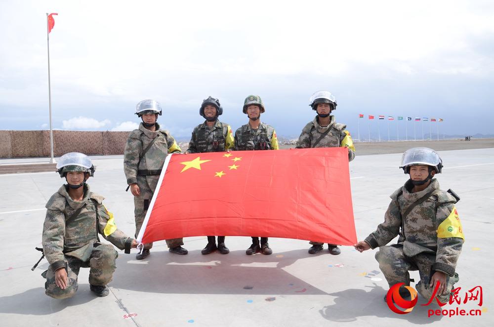 中國隊員與國旗合影。羋金攝