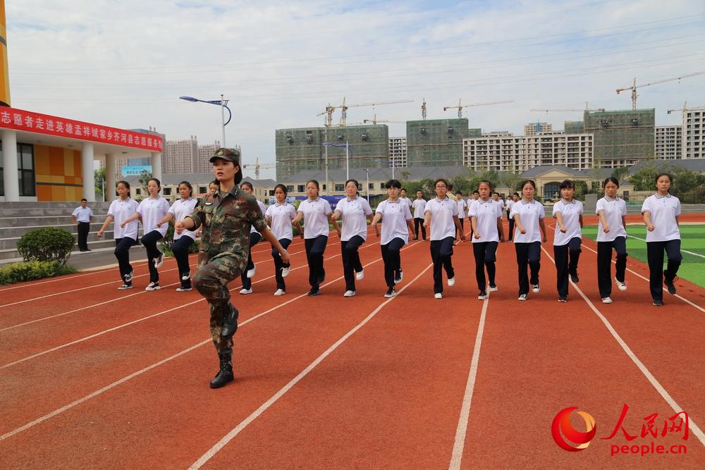 部隊官兵為中學生開展國防教育指導和隊列訓練。