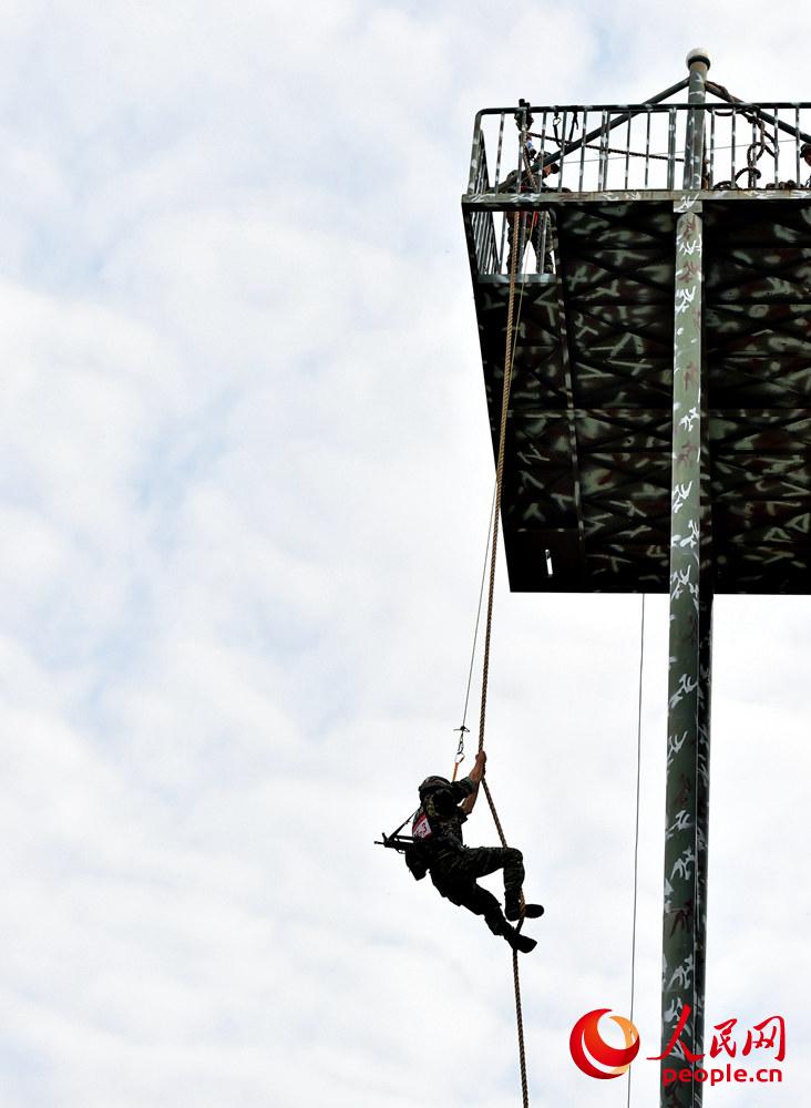 9月26日，在個人全能課目中，參賽隊員利用大繩攀爬至樓頂進行射擊。曹峰攝