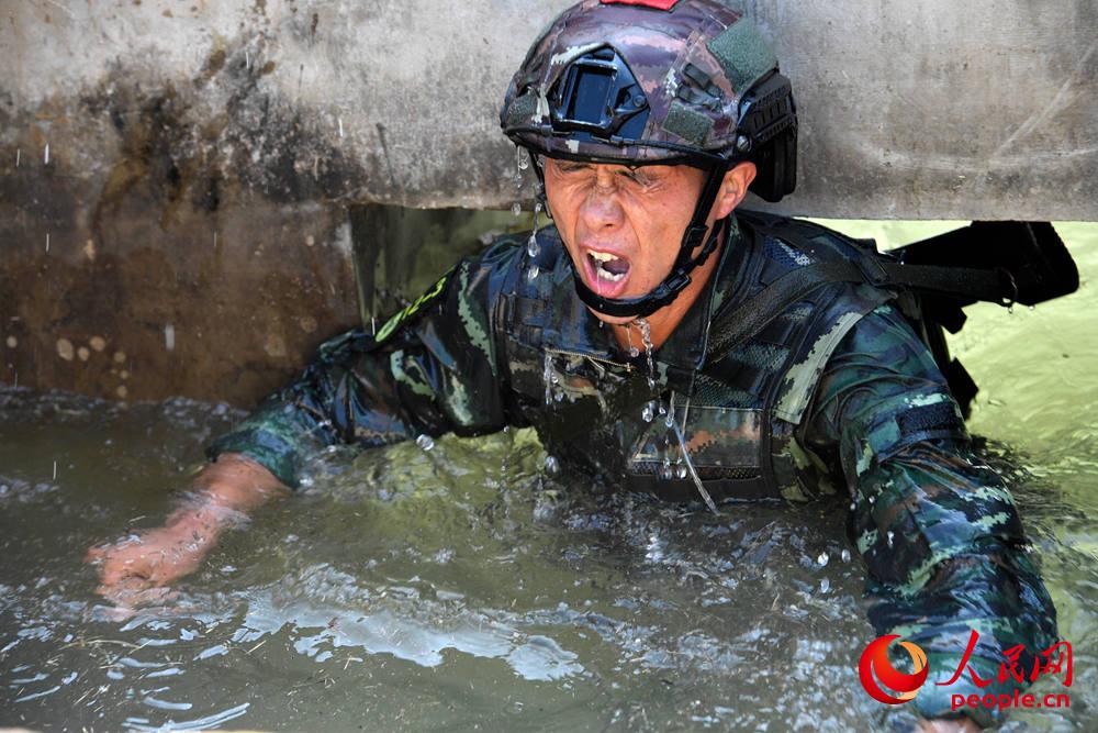 9月28日，在个人全能课目中，一名参赛队员奋力通过双升水池。李涛摄