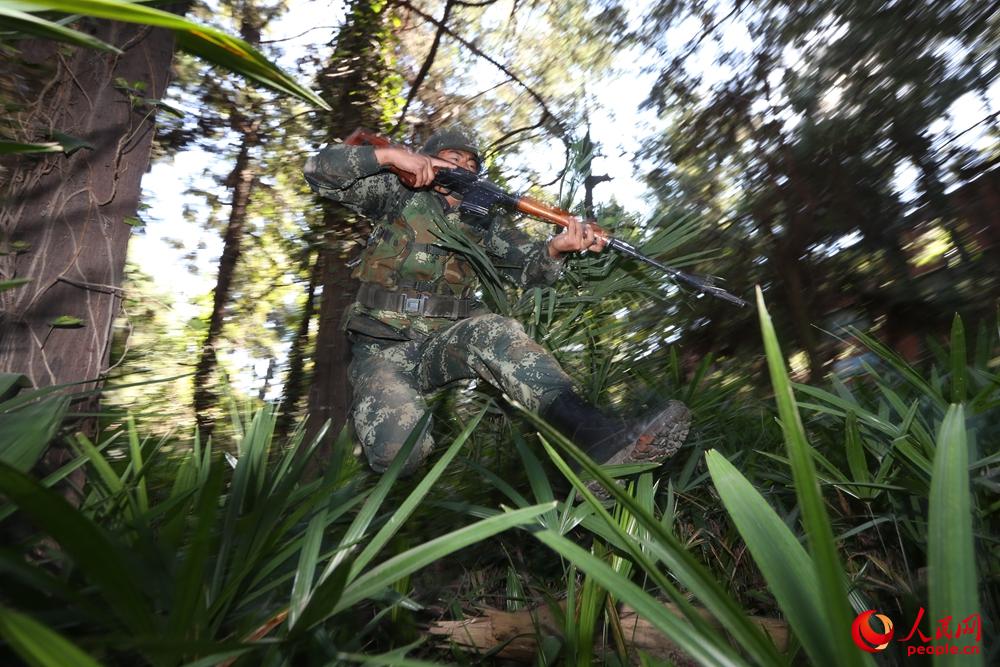 分队进行捕歼战斗演练，狙击手在山林地进行快速突击。胡程摄