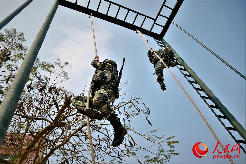 兩名官兵在進行抓繩攀登訓練。