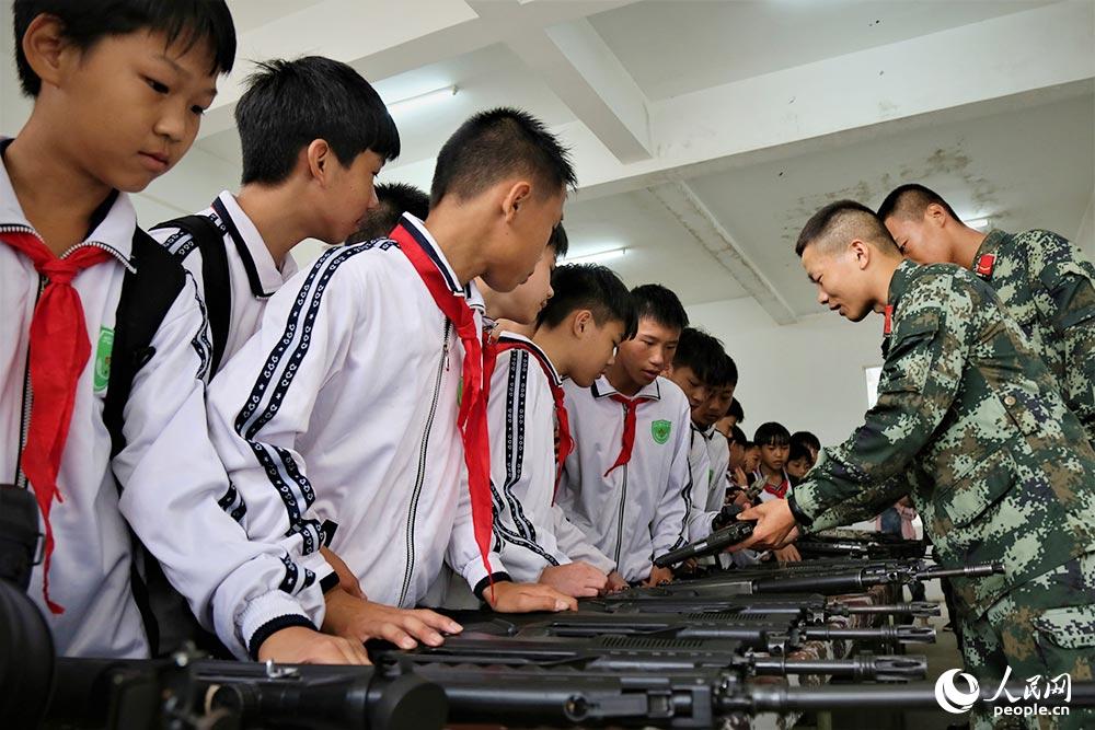 学生们在参观武警官兵们的武器装备。