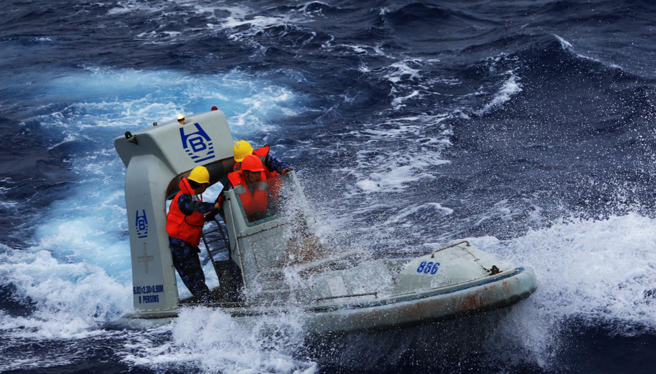 2014年3月，中国海军参与马航失联客机搜救任务，风浪中打捞疑似漂浮物。