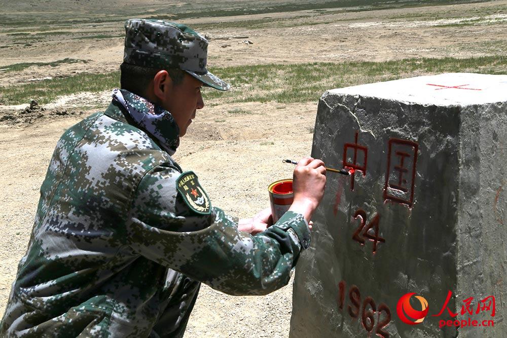 邊防戰士對界碑進行描紅。人民網記者 閆嘉琪 攝