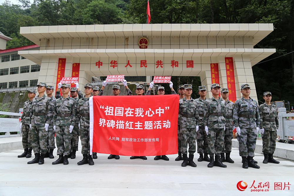 巡逻官兵与”祖国在我心中“界碑描红主题活动旗帜合影。人民网记者闫嘉琪 摄