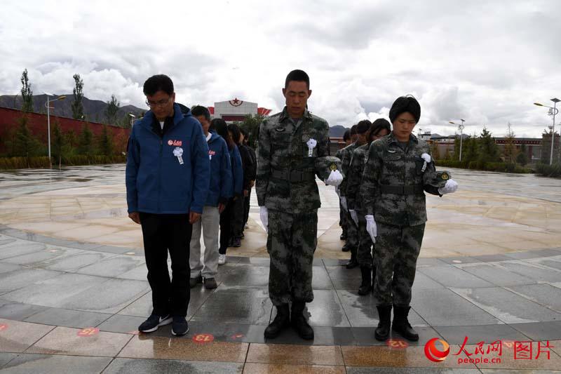 7月4日上午，人民網“祖國在我心中”界碑描紅主題活動第四採訪分隊與西藏日喀則軍分區的官兵代表們一起到日喀則烈士陵園祭奠雪域忠魂。 王乾攝