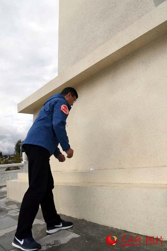 人民網採訪分隊向革命烈士紀念碑獻上小白花。王乾攝