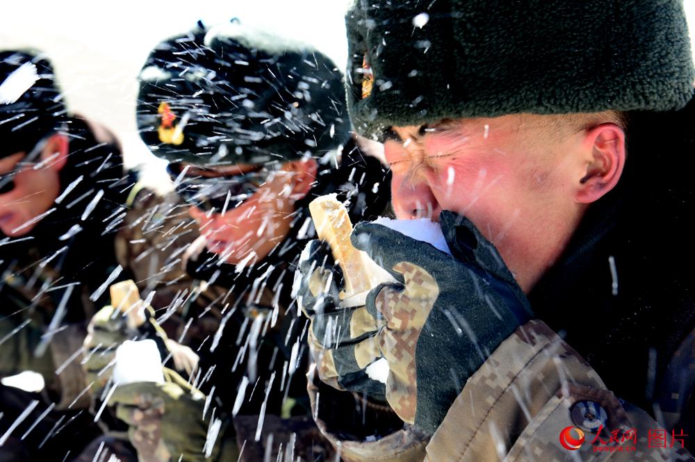 官兵在巡邏途中，由於氣溫較低，水壺裡的水凍成了冰，官兵隻能用雪塊伴干糧吃了一頓特別的午餐。羅凱攝