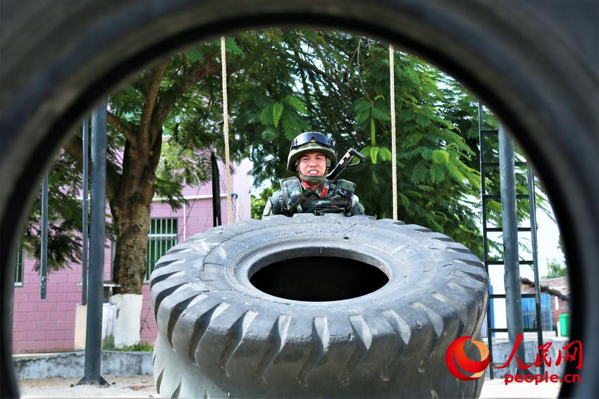 一名武警官兵在進行翻動重卡外輪胎訓練，重達300多斤的輪胎每次一翻動都需要拼盡全力。