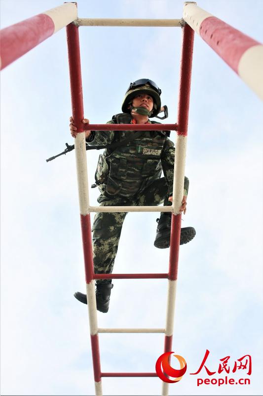 通過400米障礙訓練中，一名武警官兵快速通過雲梯。