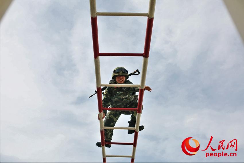 通過400米障礙訓練中，一名武警官兵快速通過雲梯。