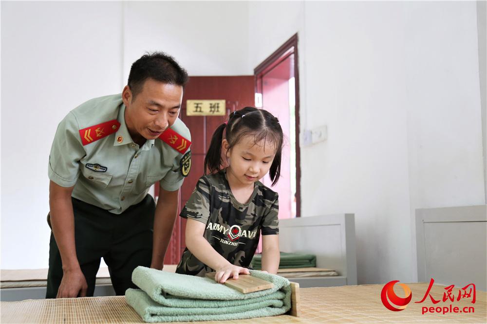 在陳蘇華的幫助下，陳淑婷學習疊部隊的毛毯。