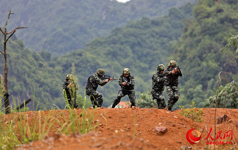 戰術訓練中，武警官兵交替掩護通過開闊地。