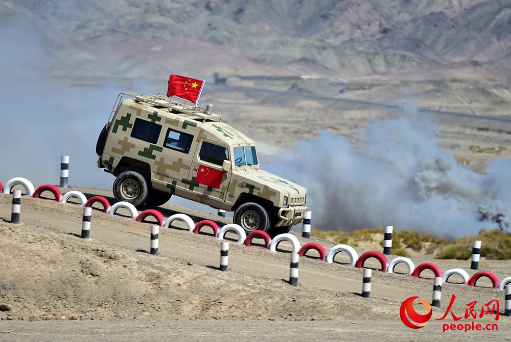 中國參賽隊員駕駛車輛飛躍小山丘。