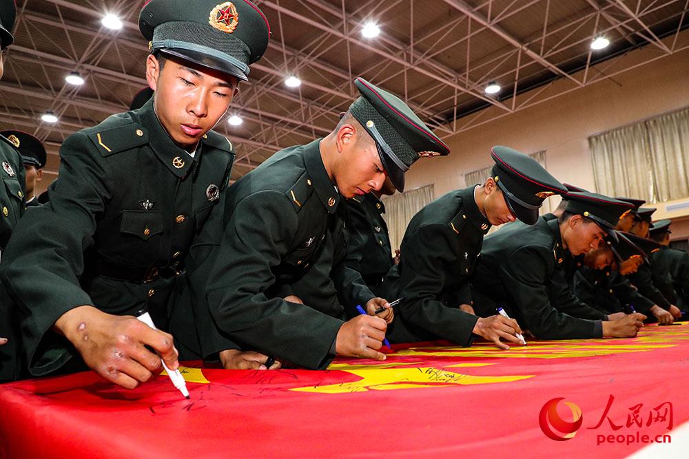 經歷80天磨練，一名新戰士在簽名時露出了手上“光榮勛章”。
