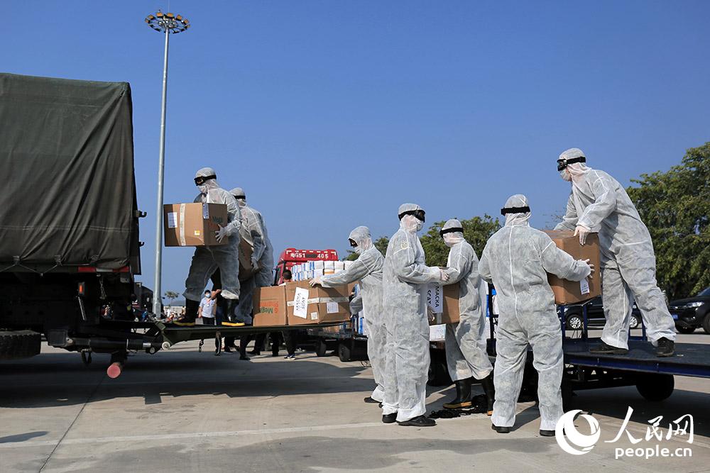 武警官兵在三亞鳳凰機場搬運防疫物資。