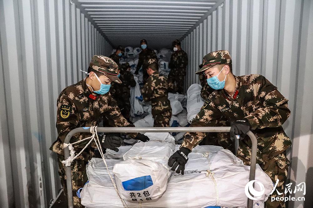 2月9日，武警官兵正在搬運救援物資。