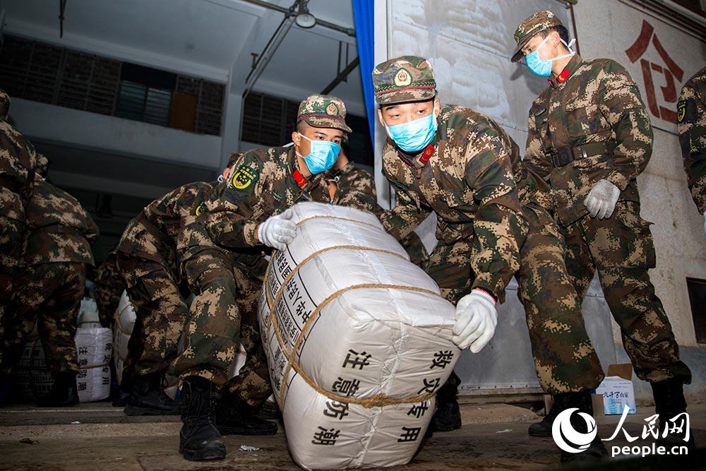 2月9日，武警官兵正在搬運救援物資。