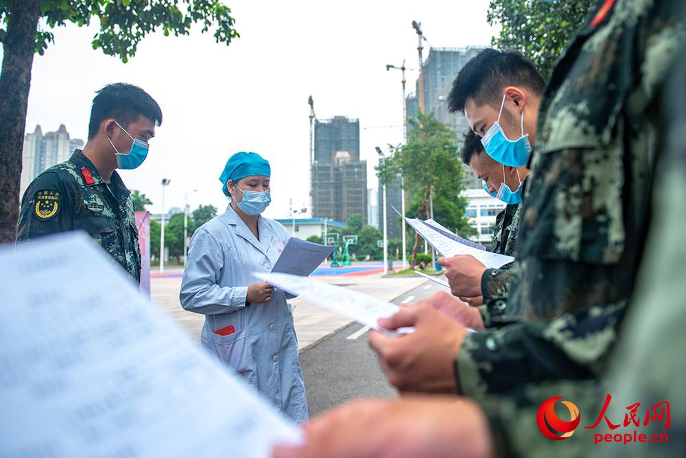 醫護人員向武警官兵講解獻血注意事項。