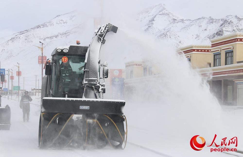 利用拋雪機清理路面積雪。