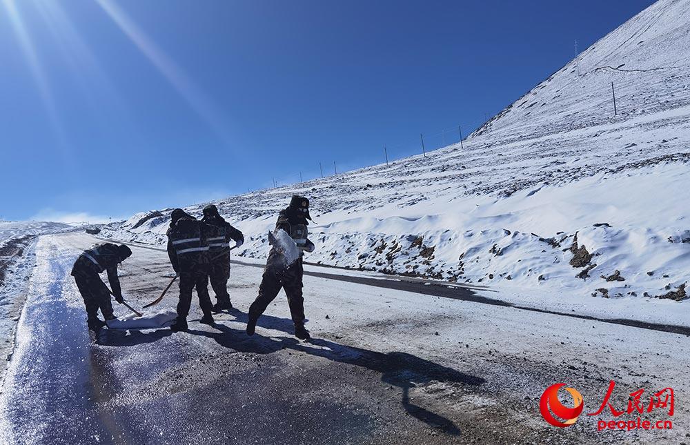 救援官兵對結冰路段拋洒工業鹽。