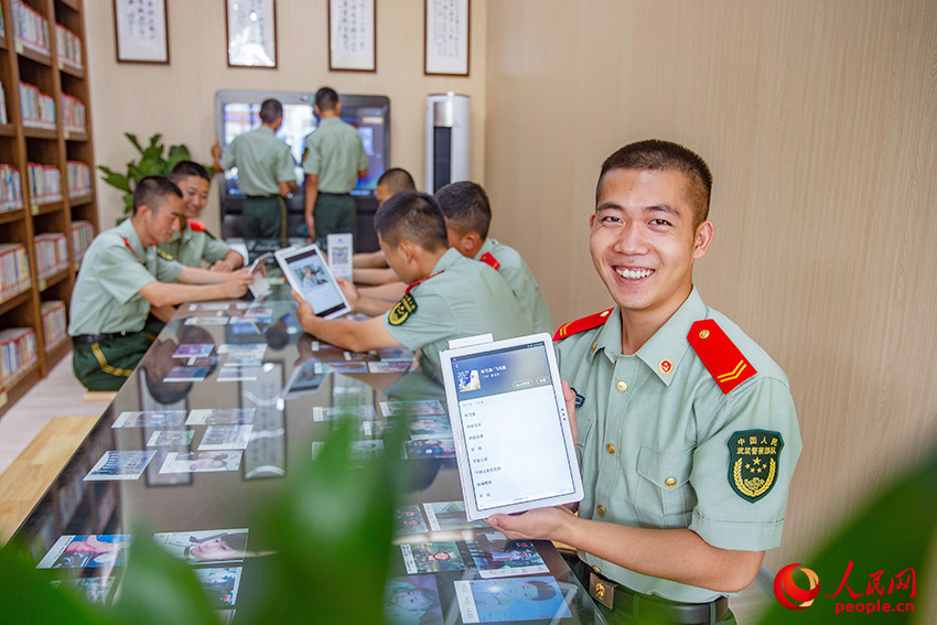 官兵运用平板电脑浏览书籍，进行网课学习。
