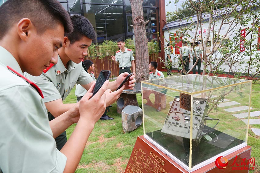 官兵使用手机扫码浏览中队历史和驻地红色故事。