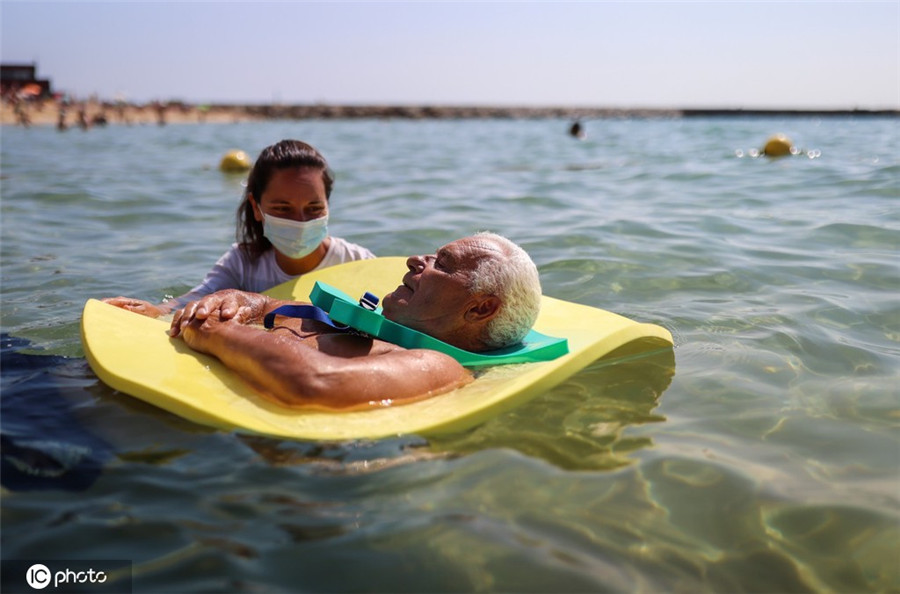 西班牙海灘救生員幫助殘疾人體驗海中游泳