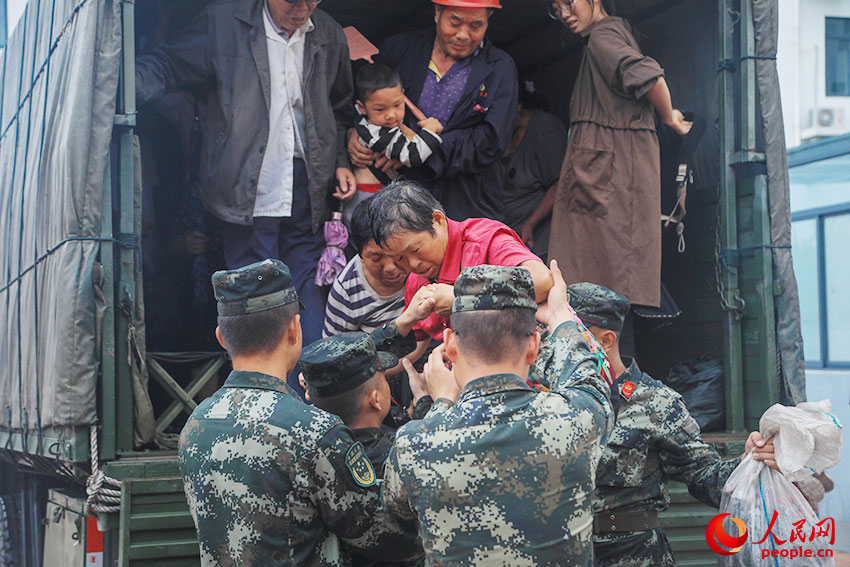 7月20日，武警第一机动总队某支队官兵在河南登封转移受灾群众。