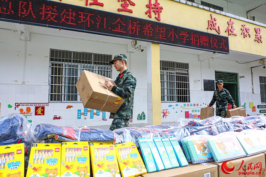 武警官兵为学校师生送来学习工作用品和生活物资。
