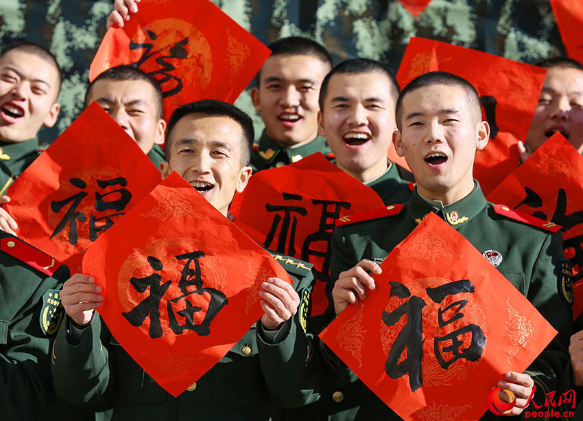 官兵們展示著手中的“福”字，臉上洋溢著燦爛的笑容。