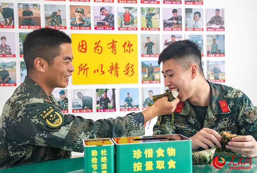 一起吃著粽子，官兵臉上露出喜悅笑容。