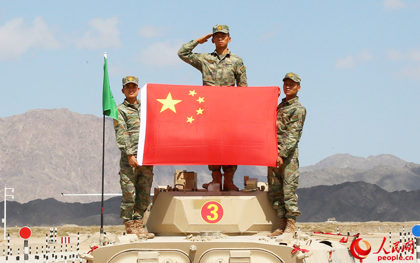 中国参赛车组到达终点后展示国旗。