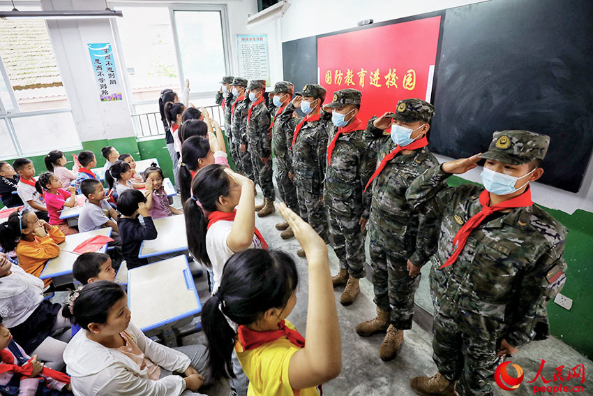 國防教育活動現場，武警漢中支隊官兵與學生們互相敬禮。
