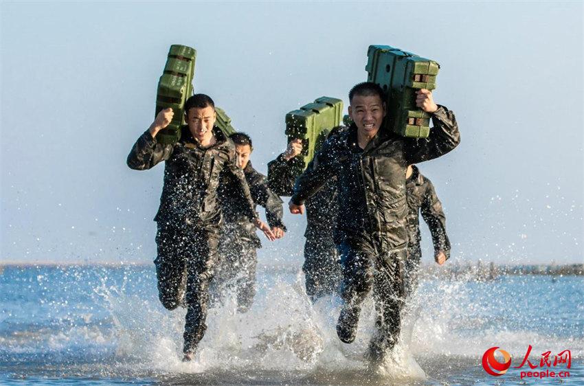 武警官兵在海水中进行负重冲刺训练。