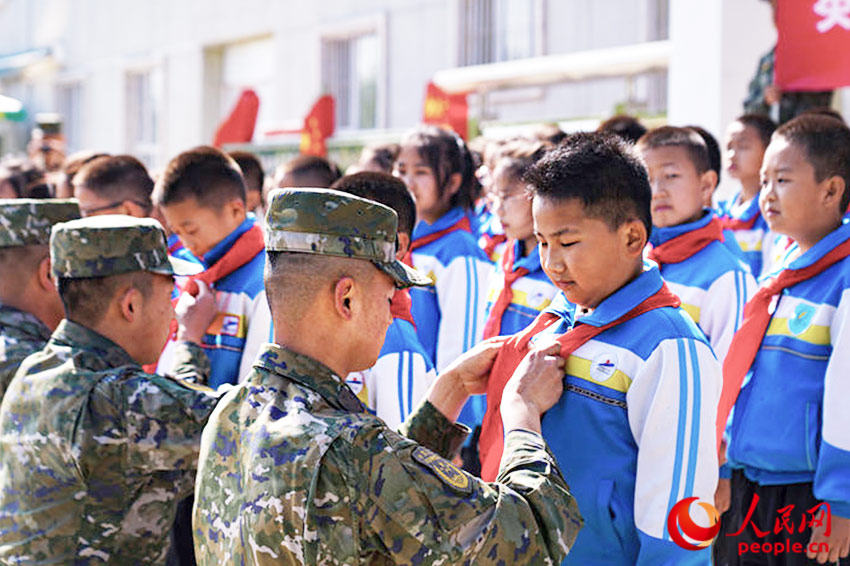 少先隊員入隊儀式中，官兵為新少先隊員佩戴紅領巾。
