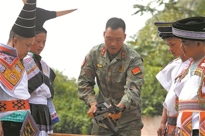 上图：9月8日，贵州省纳雍县民兵向化作乡枪杆岩村苗族群众讲解步枪性能。王庆泽摄