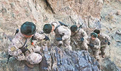 图②：民兵互帮相助，一异攀爬陡峻山坡。