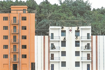 上图：参训官兵利用绳索进入房间搜救“人质”。晏 恪摄