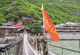 近日，四川省泸定县人武部组织民兵重走长征路。图为队伍行进在泸定桥上。张  政摄