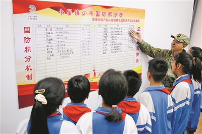 在小留鎮黨群服務中心，牡丹區人武部工作人員介紹“少年國防積分”榜上學生積分情況。劉繼璐攝
