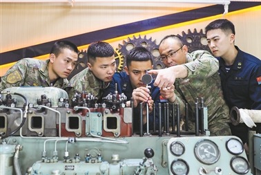 海軍某試驗艦中心一級上士張慶山（右二）為戰友們講解裝備狀態情況測量方法。