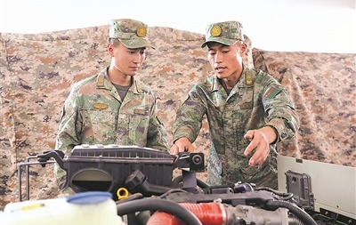 雷耀明（右）给战友讲解装备操作要点。马新周 摄