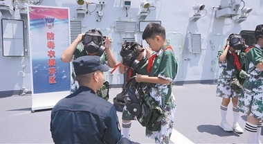 河北省石家庄市華夏小學學生在海軍石家庄艦上體驗穿戴防護設備。李鳳祥 攝