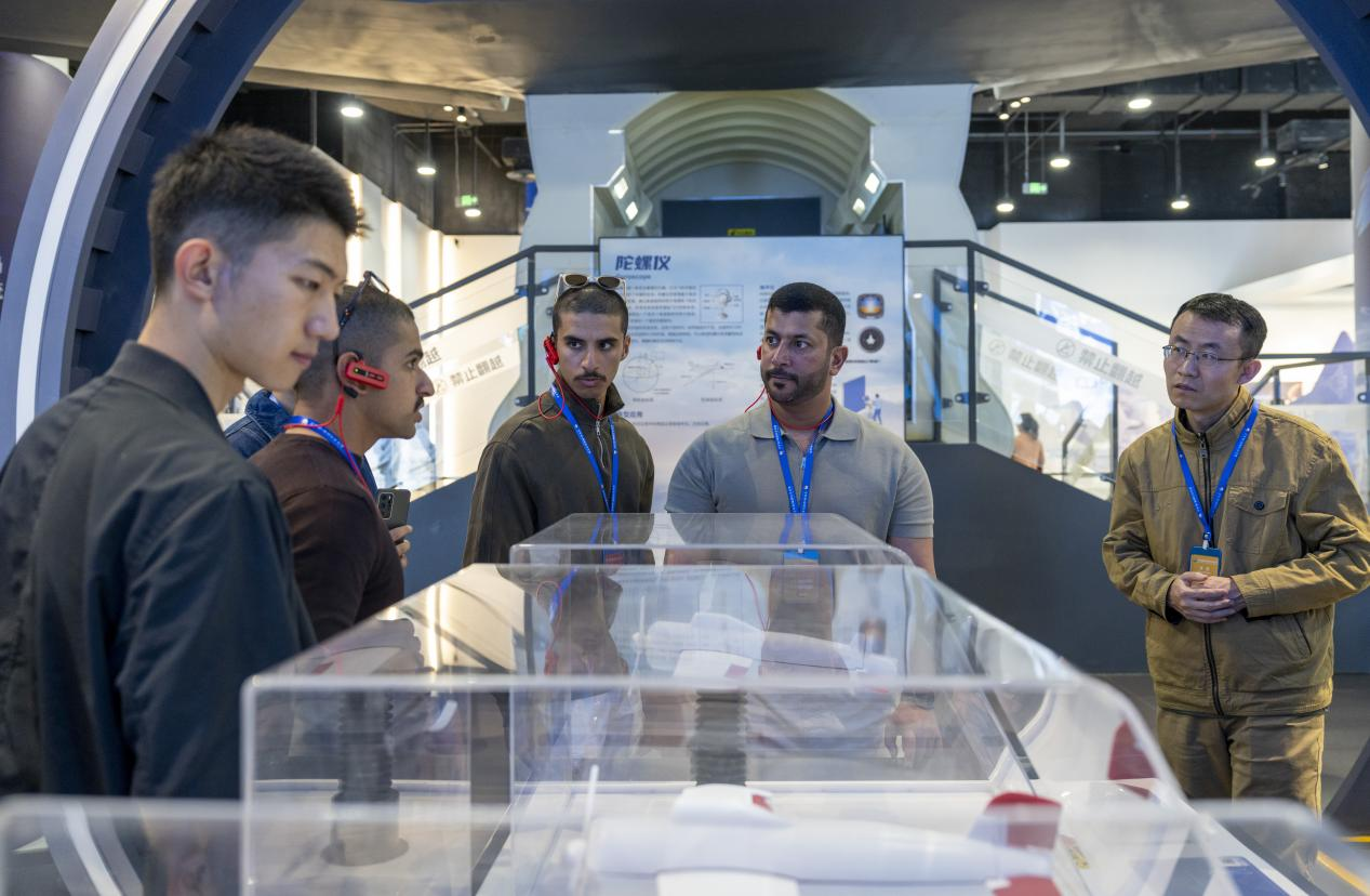 11月3日，空军第六届国际学员周组织中外学员参观科技馆，学员们在参观间隙分享飞行心得。人民网记者 唐宋摄