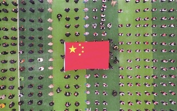 学校国旗护卫队护送国旗从学生中间穿过（无人机照片）。阿布都卡地尔摄