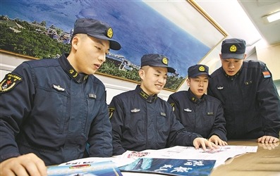 “砺刃报”主编倪呈辉(左二)与战友围看新一期“砺刃报”。 张 楠摄